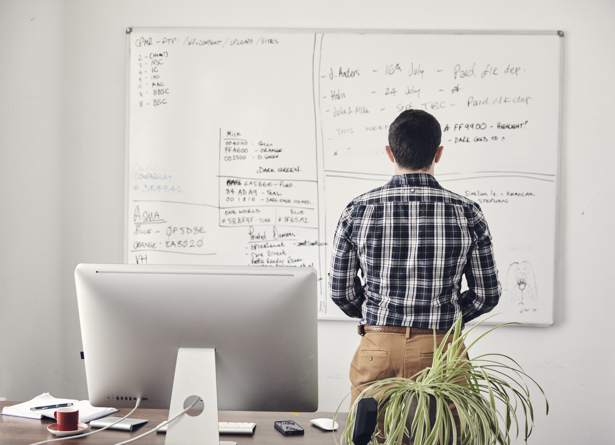 Man looking at a whiteboard thinking what to outsource as a first time outsourcer
