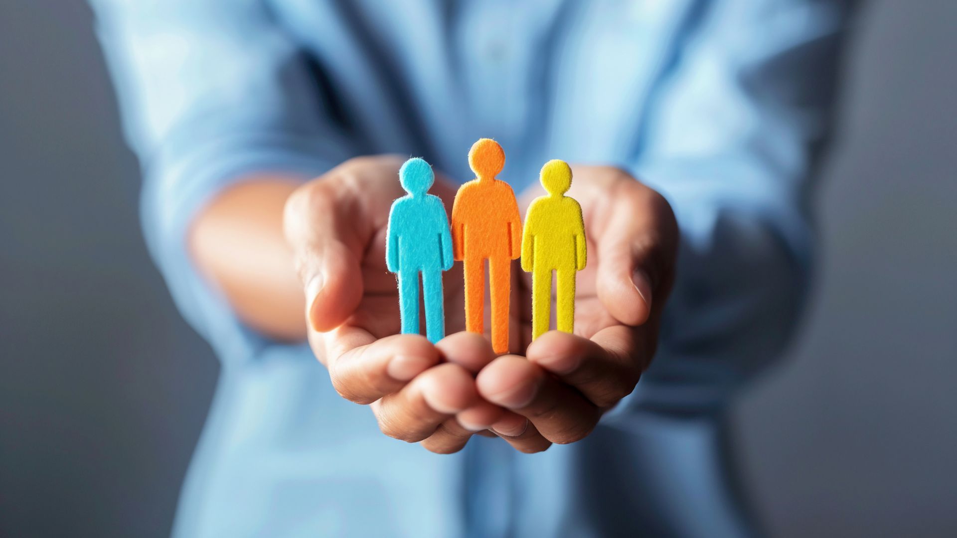 A pair of hands holding a figurine symbolizing employee wellness.